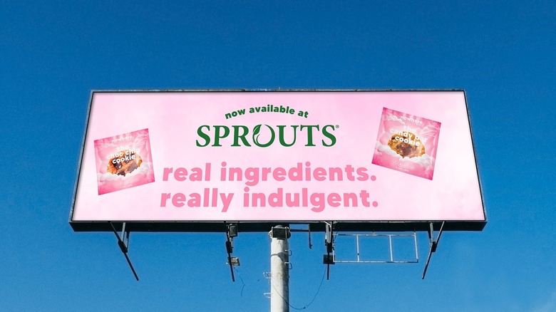 A billboard for Nowhere Bakery at Sprouts stores stands tall against a blue sky