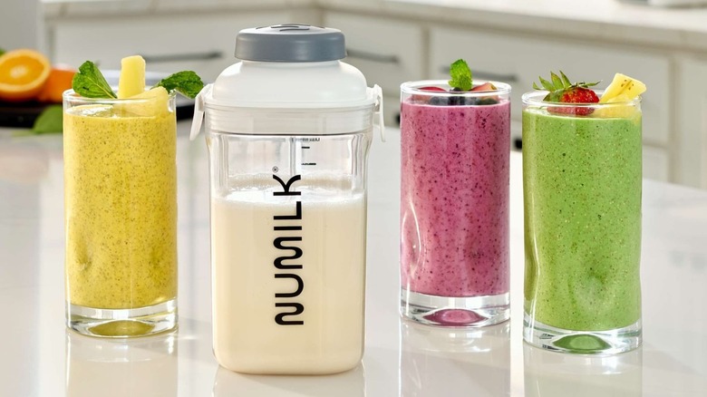 A jug of Numilk next to several flavors of smoothies