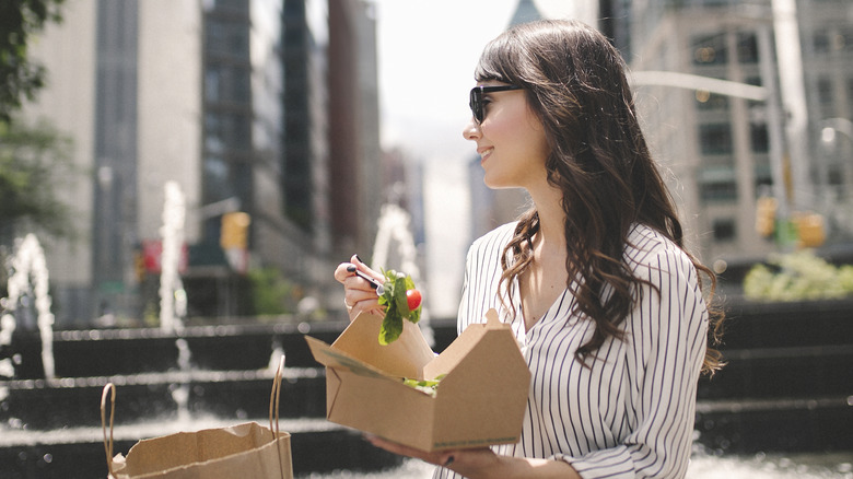 woman eating salad in park