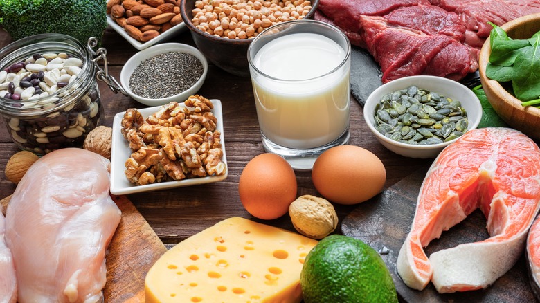 Table filled with eggs, meat, nuts, and a glass of milk
