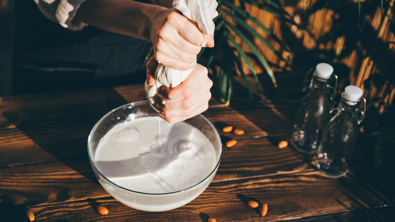 Woman making homemade almond milk