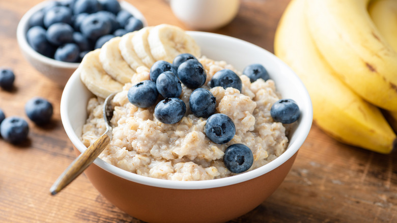 a bowl of steel-cut oats topped with blueberries and slices of banana
