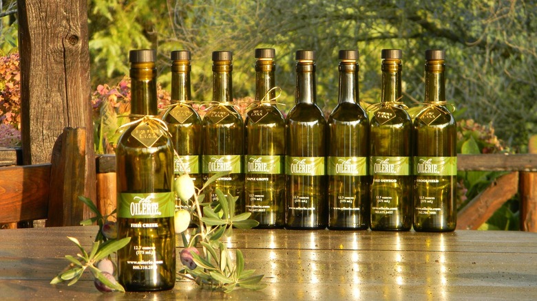 Eight bottles of Oilerie olive oil on wood table