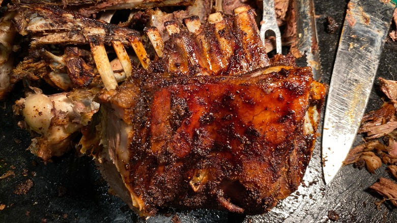 Grilled goat ribs on black surface
