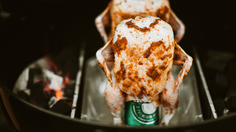 Whole chicken on a beer can in a barbecue