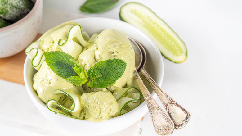 Bowl of cucumber ice cream served with thinly sliced pieces and mint