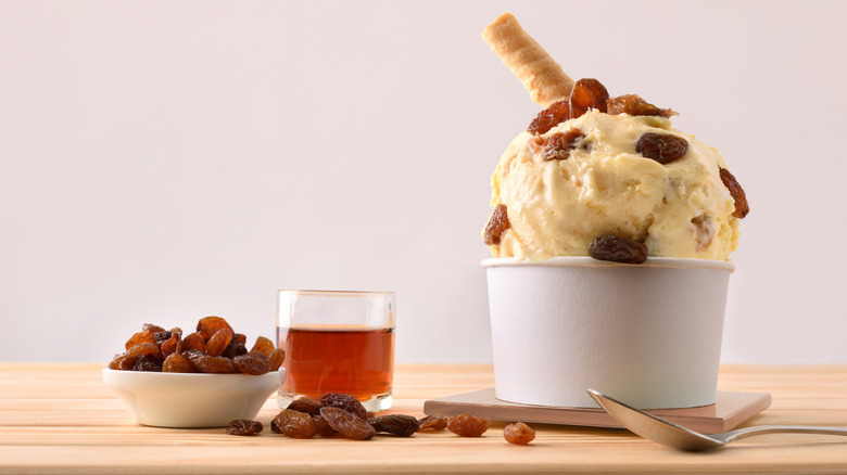 Heaping portion of rum raisin ice cream with a cookie jutting out beside the namesake ingredients