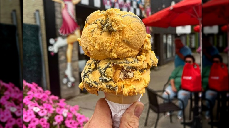 Bright orange scoop of Tiger Tail ice cream with black licorice stripes running through it