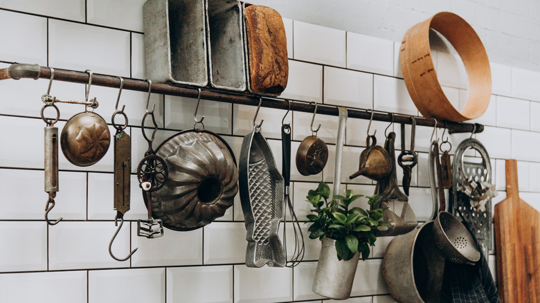 Various vintage kitchen tools hanging on a rack