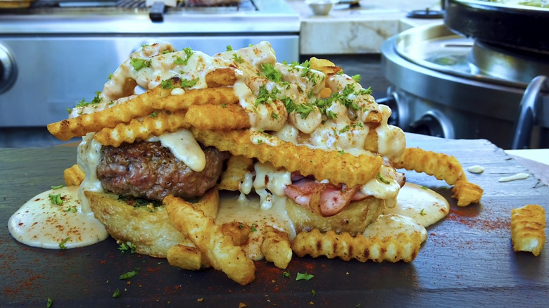 Open face sandwich piled high with crinkle-cut fries, meat, and cheese sauce
