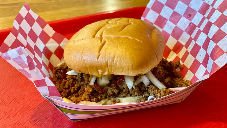 Loose meat sandwich on checkered paper in a food boat