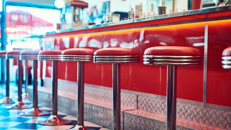 Red swivel stools at a retro diner counter