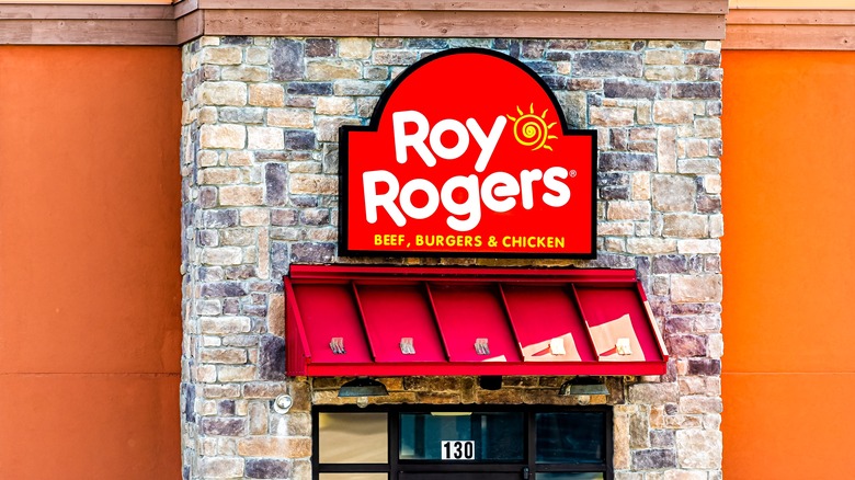 Stone facade and orange paint present a backdrop for a Roy Rogers sign