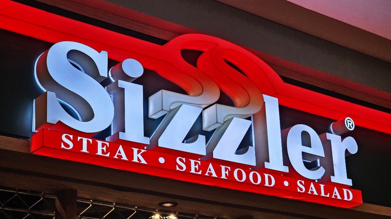 Sizzler signage illuminated in white and red