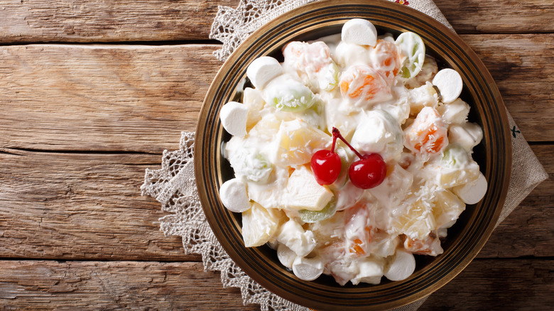 Ambrosia salad in a bowl, placed on a wood background