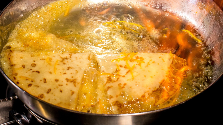 Crepes Suzette being flambéd in a pan