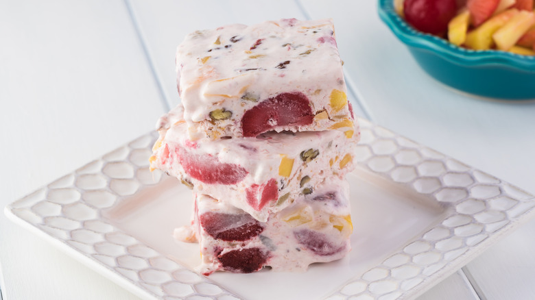 Squares of frozen fruit salad stacked on a plate
