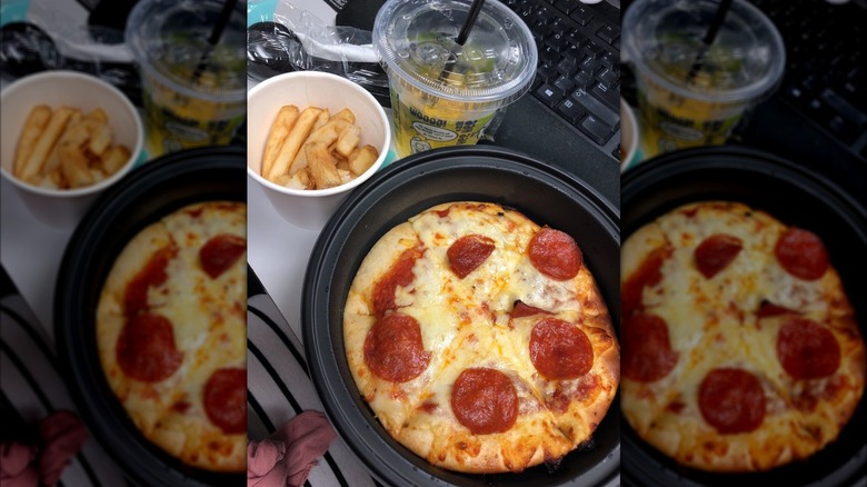 A miniature pepperoni pizza with a drink and fries from Olive Garden.