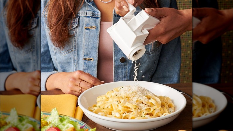 Grating cheese over pasta at Olive Garden.