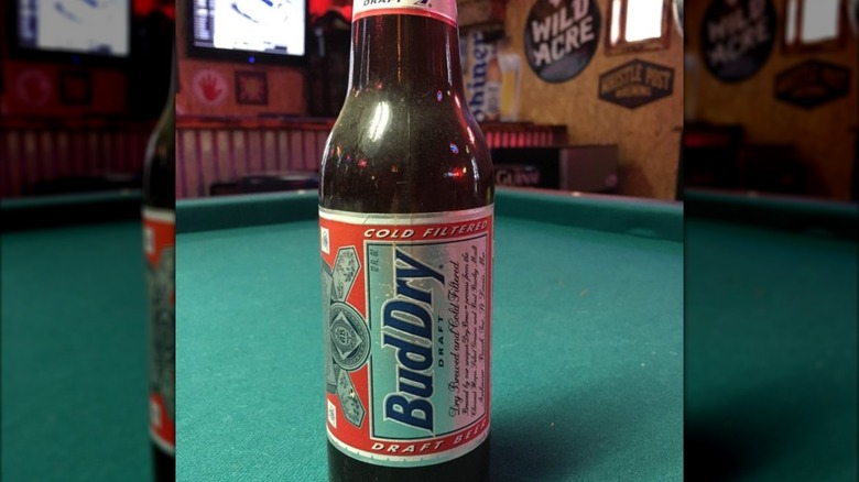 A bottle of Bud Dry on a pool table in a bar