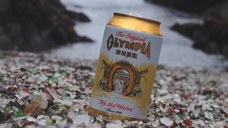 Olympia Beer can on a beach with lots of sea glass