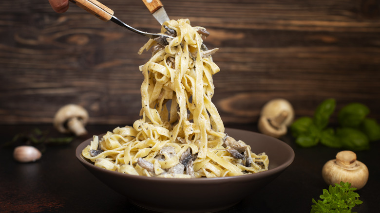 mushroom fettuccini pasta on a brown plate