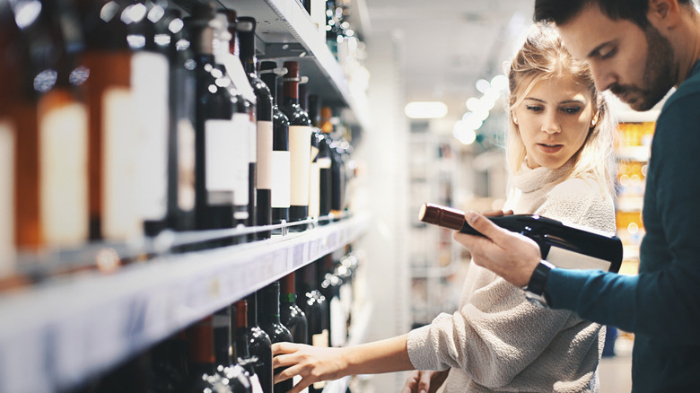 young couple purchasing a bottle of wine