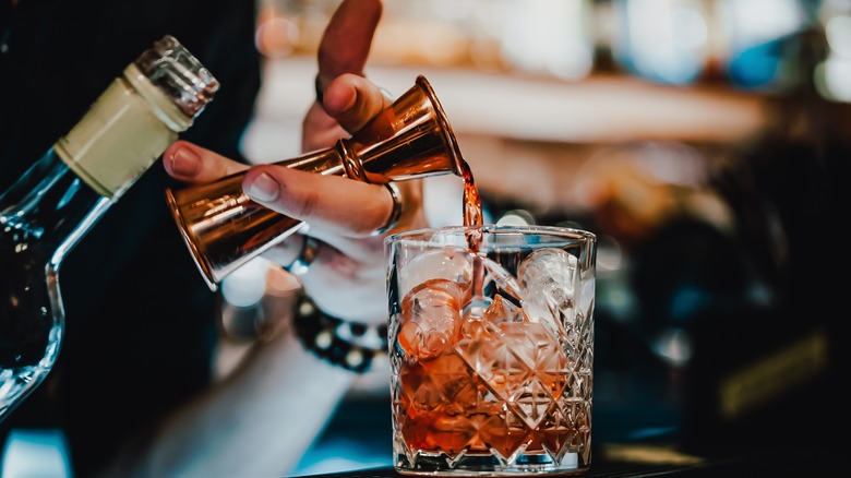 Bartender mixing negroni drink