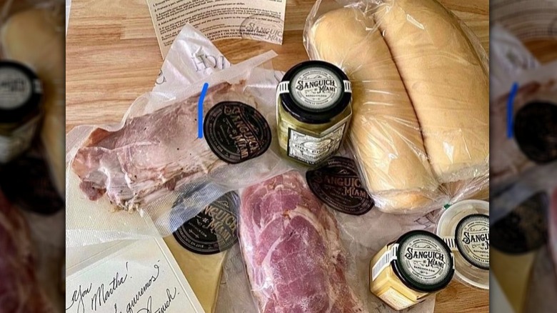 The ingredients for Sanguich De Miami's Cuban sandwich laid out on a wooden surface