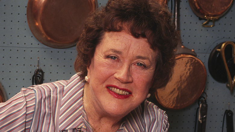 Julia Child in kitchen with food pots and pans