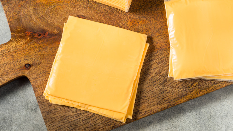 Piles of American cheese on cutting board