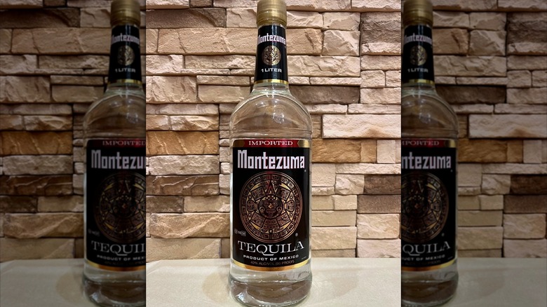 a bottle of Montezuma Tequila against a stone background