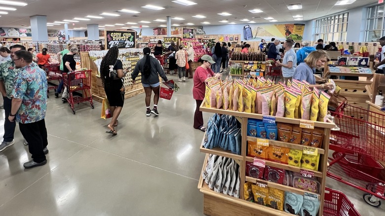 A crowd of people mill around a Trader Joe's store