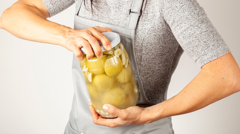 Person struggling to open a jar