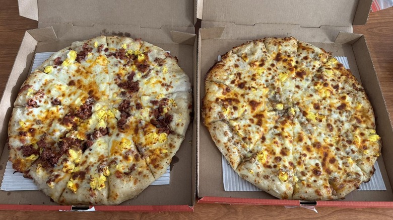 Two Casey's breakfast pizzas sit on a table.
