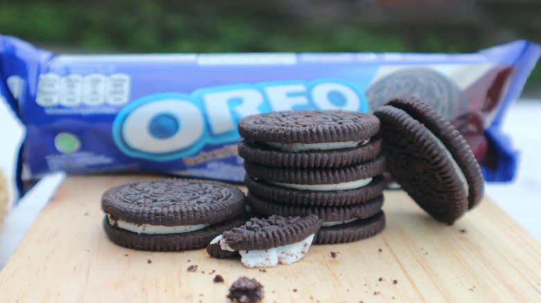 Oreo cookies sitting on a wooden board with a package in the background