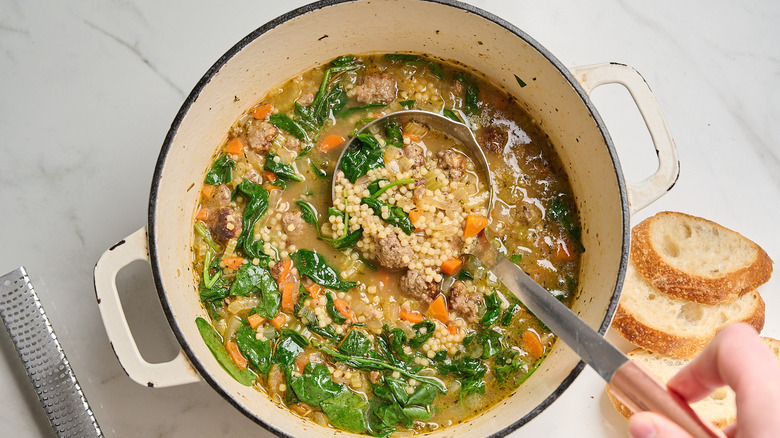 Ladling Italian wedding soup out of pot