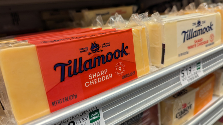 tillamook sharp cheddar in yellow and white on a grocery store shelf