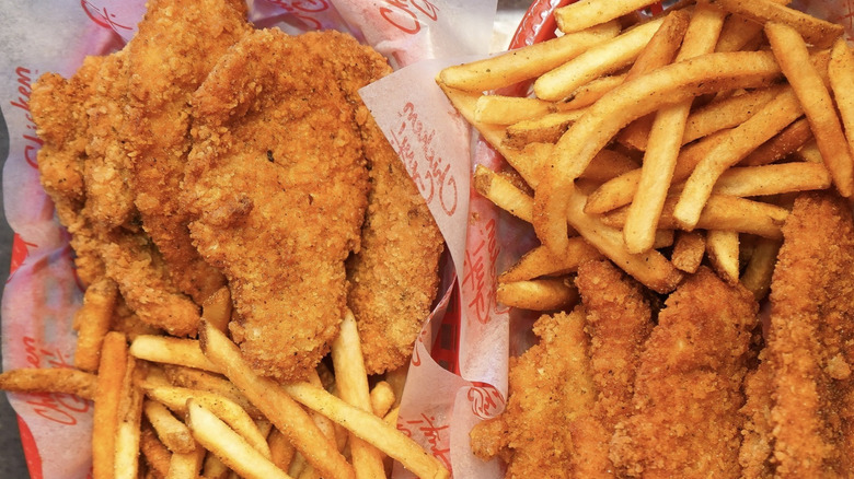 Chicken tenders and french fries from Chicken Guy! sit in paper-lined baskets on a tray