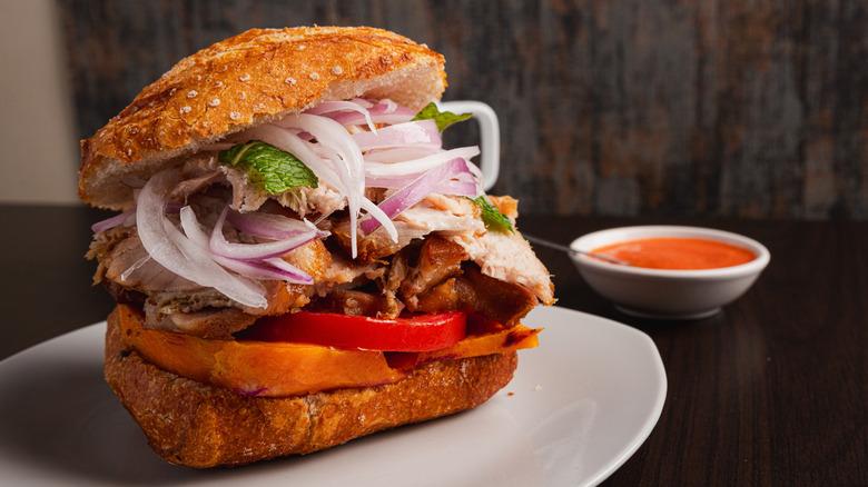 pan con chicharrón served with a side of sauce