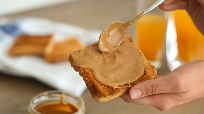 A nut butter being spread on toast