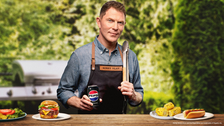 Chef Bobby Flay outdoors with grilled food and can of new Pepsi flavor