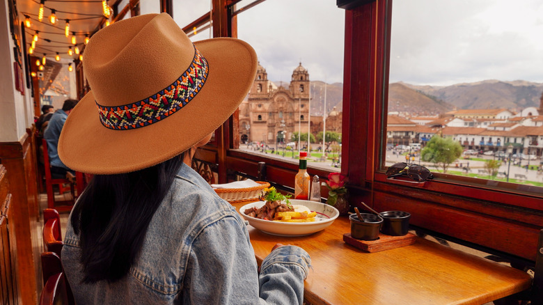 A tourist enjoying a meal overlooking the plaza in Cuzco.