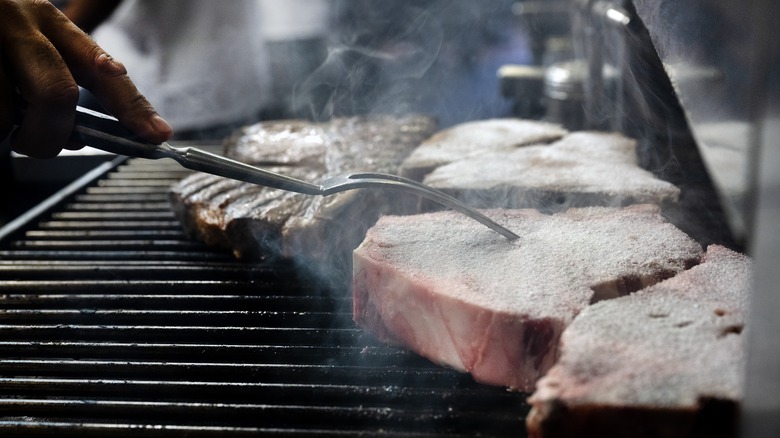 Poking steak cooking on broiler
