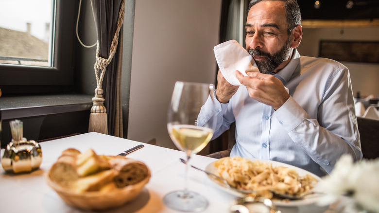 man using napkin in restaurant