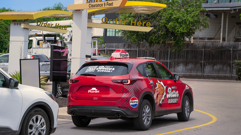 Pizza Hut delivery car in McDonald's drive-thru