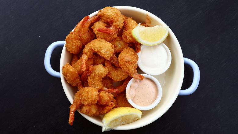served bowl of popcorn shrimp with two dips and lemon wedges