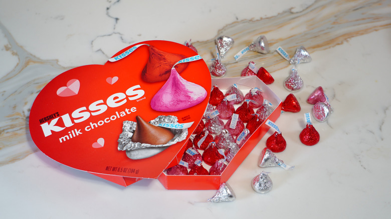 An open heart-shaped box of Hershey's Kisses