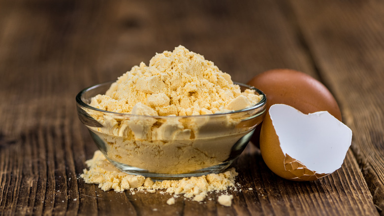 bowl of powdered eggs next to eggshell
