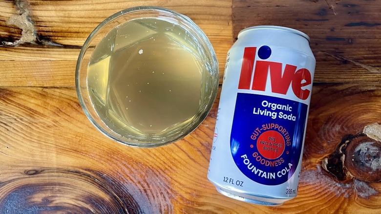 Overhead view of a can and glass of Live Fountain Cola on a wooden table top